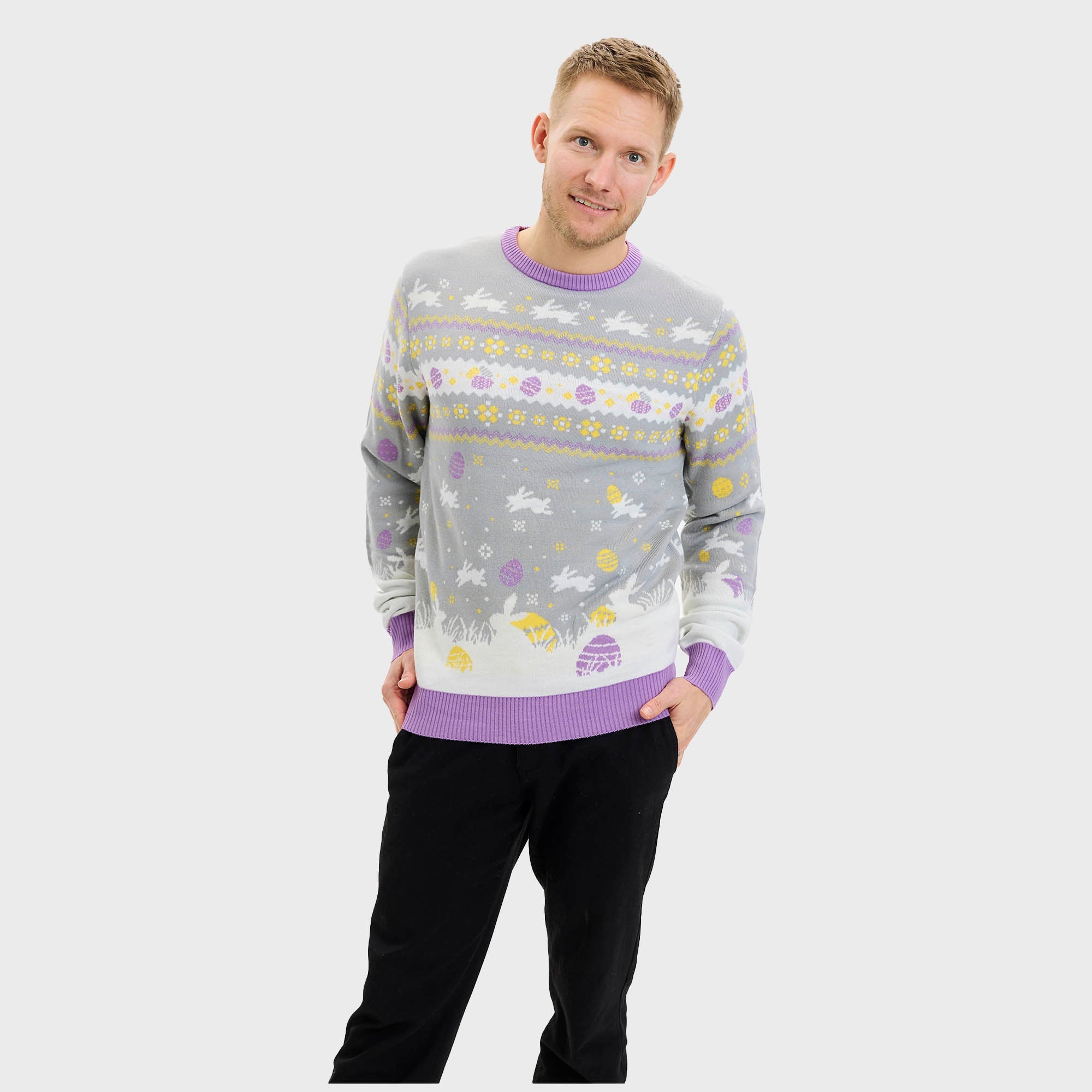 En smilende mann har på seg en grå påskegenser med kaniner på.